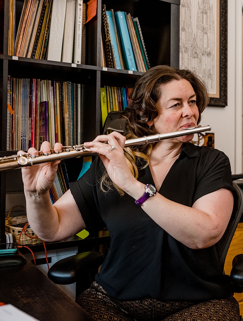 front page pic adult woman playing the western silver flute in her music room